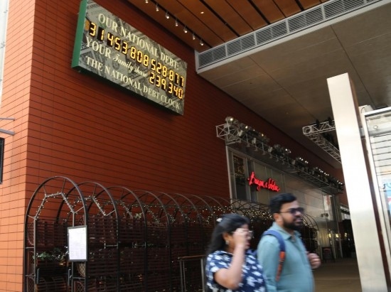 2023年5月29日，人們經(jīng)過(guò)美國(guó)紐約曼哈頓的“國(guó)債鐘”。“國(guó)債鐘”是一個(gè)大型計(jì)數(shù)器，它實(shí)時(shí)更新美國(guó)的公共債務(wù)總額，并顯示出每個(gè)美國(guó)家庭所要負(fù)擔(dān)的數(shù)額。 新華社記者劉亞南攝