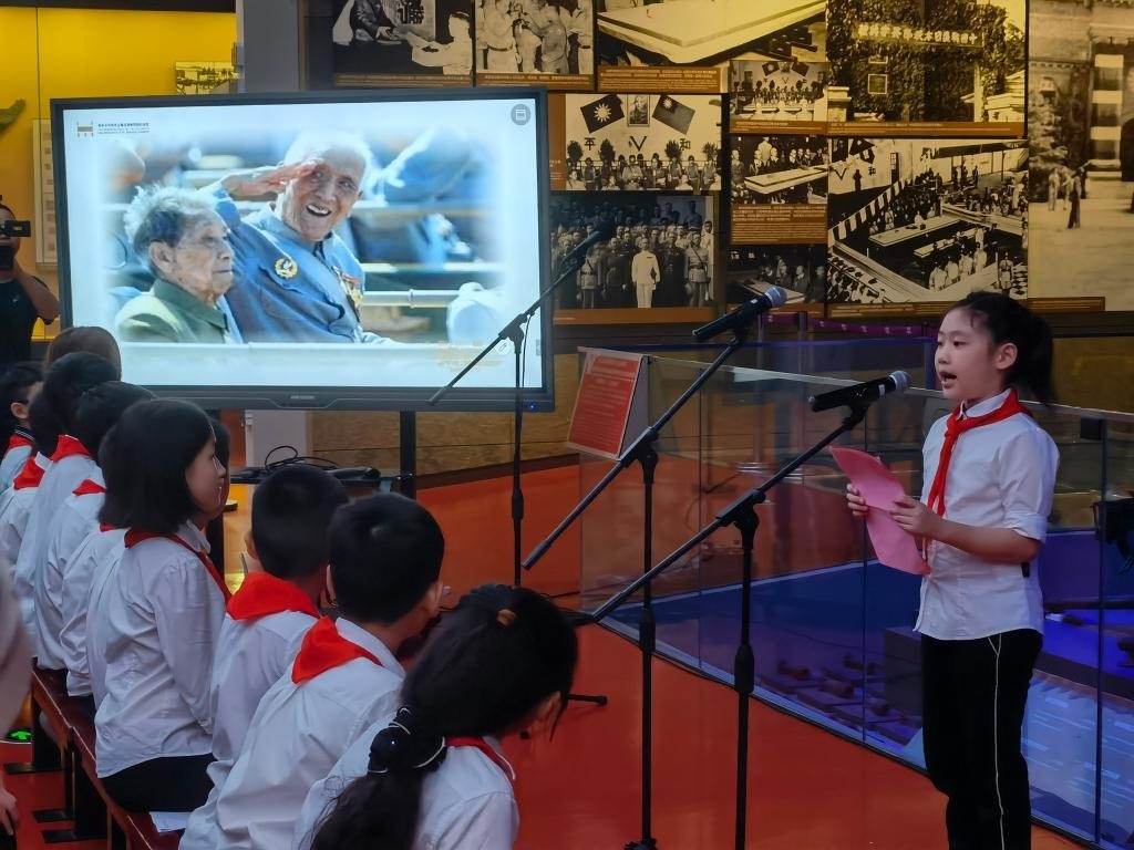 南京市科睿小學(xué)二年級學(xué)生章若初為大家講述抗戰(zhàn)老兵手印的故事。 新華社記者 邱冰清 攝