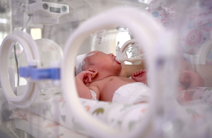 2024年6月1日，在西安國(guó)際醫(yī)學(xué)中心醫(yī)院新生兒科病房，護(hù)士為新生兒喂奶。 新華社記者 劉瀟 攝