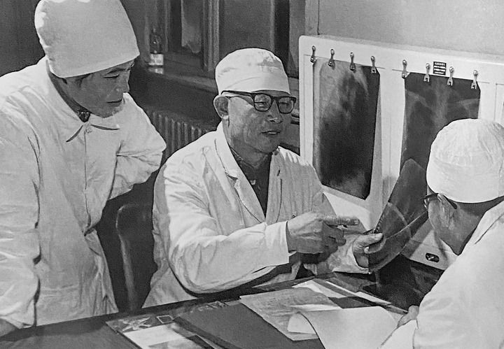 1980年1月16日，中日友好醫(yī)院首任院長(zhǎng)辛育齡（中）在內(nèi)蒙古結(jié)核病院與胸外科醫(yī)師討論病例（翻拍照片）。 新華社發(fā)