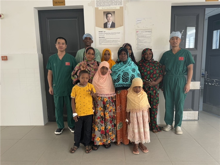 李廣(右一)和王林醫(yī)生與部分患者合影。中國援桑醫(yī)療隊供圖