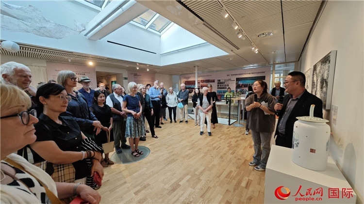 參展人、景德鎮(zhèn)陶瓷大學(xué)美術(shù)學(xué)院副院長邵長宗（右一）向來賓介紹參展作品。人民網(wǎng)記者 殷淼攝