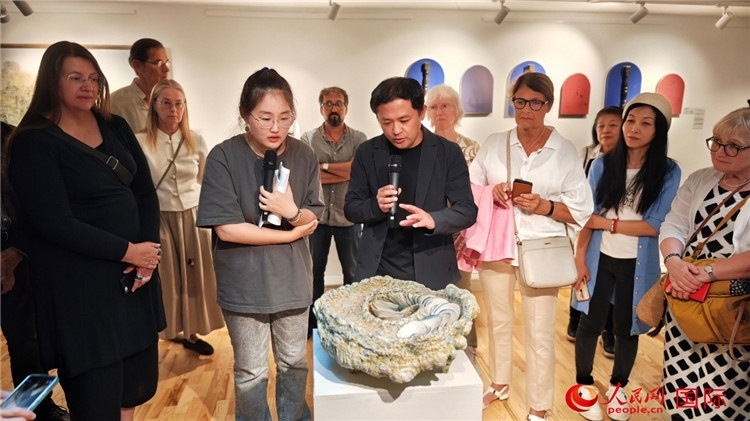 參展人、景德鎮(zhèn)陶瓷大學(xué)設(shè)計(jì)藝術(shù)學(xué)院副院長余劍峰（中）向來賓介紹參展作品。人民網(wǎng)記者 殷淼攝