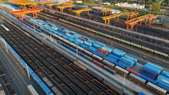 這是2024年8月14日在黑龍江綏芬河鐵路口岸集裝箱換裝場拍攝的集裝箱換裝作業(yè)現(xiàn)場（無人機照片）。今年前七個月，綏芬河鐵路口岸開行中歐班列573列，運量達55246標箱，同比分別增長23%和18%，班列數(shù)量持續(xù)保持高位運行。