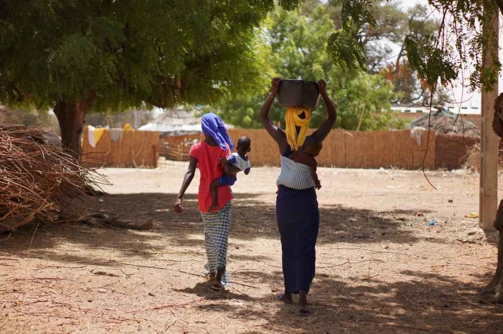 2023年3月20日，在塞內(nèi)加爾久爾貝勒區(qū)的泰內(nèi)富勒村，村民將取到的水運(yùn)回家。新華社記者 王子正 攝