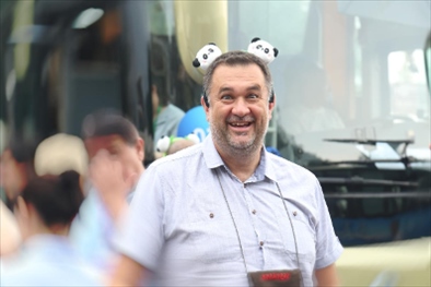 參訪熊貓谷前，塞爾維亞“一帶一路”研究所所長博揚·拉利奇戴上熊貓頭飾。（李佩藺 攝）