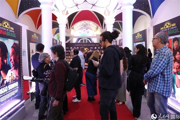 為期4天的第三屆中國－巴西電影展期間，來自中巴兩國的14部參展影片受到巴西電影愛好者和社會各界人士好評，圖為當地觀眾在影展舉辦地巴西里約熱內盧勞拉—阿爾維姆文化之家的迎賓廳欣賞參展電影海報。 人民網記者 陳一鳴攝