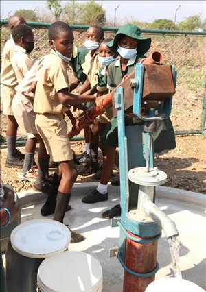 △2021年11月，在津巴布韋南馬塔貝萊蘭省省會關達的塞農(nóng)多小學，學生從中國援建水井里打水。