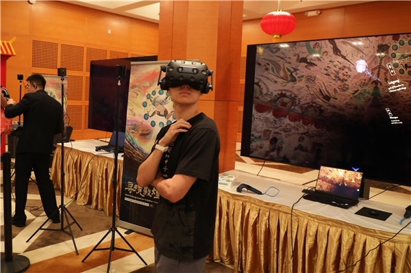 1、在本次活動的展覽現(xiàn)場，敦煌研究院與騰訊展示了“數(shù)字藏經(jīng)洞”和“尋境敦煌”等創(chuàng)新互動產品。圖為當?shù)孛癖娡ㄟ^VR虛擬游覽洞窟。 人民網(wǎng)記者 李志偉攝