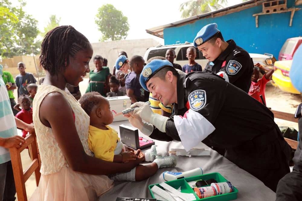 2017年12月28日，在利比里亞蒙羅維亞，中國維和警察防暴隊醫(yī)療人員為兒童做口腔檢查。
