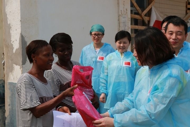 2015年4月4日，在位于塞拉利昂首都弗里敦市郊的中塞友好醫(yī)院埃博拉診療中心，中國第四批援塞醫(yī)療隊副隊長邵蔚（右前）向被治愈的埃博拉出血熱患者贈送禮物。新華社發(fā)（祖榮強(qiáng) 攝）