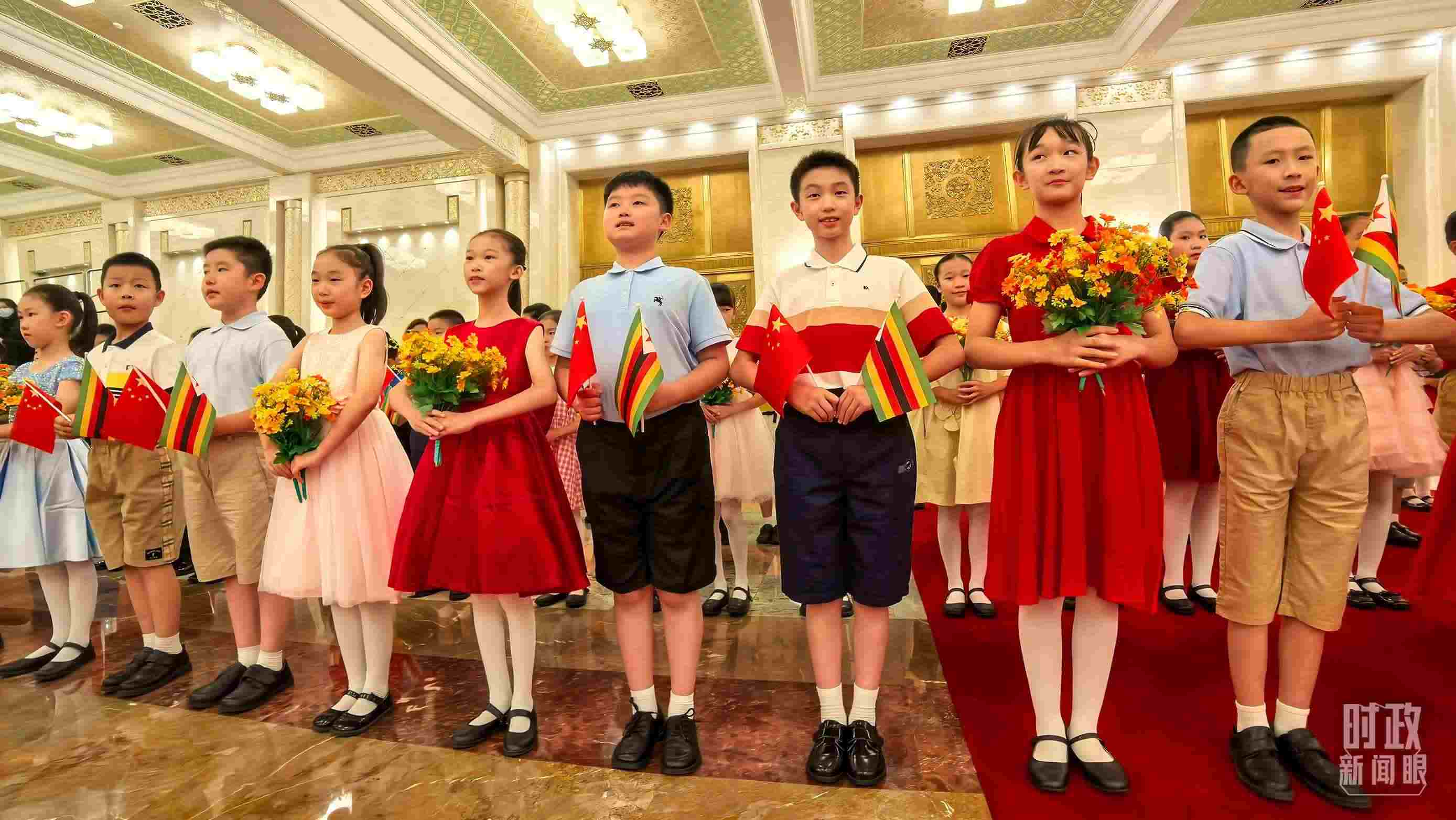 △現(xiàn)場歡迎津巴布韋總統(tǒng)訪華的青少年。（總臺央視記者鐘銳拍攝）