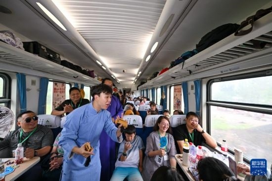 9月7日，相聲演員在S910列車上為旅客表演快板。
