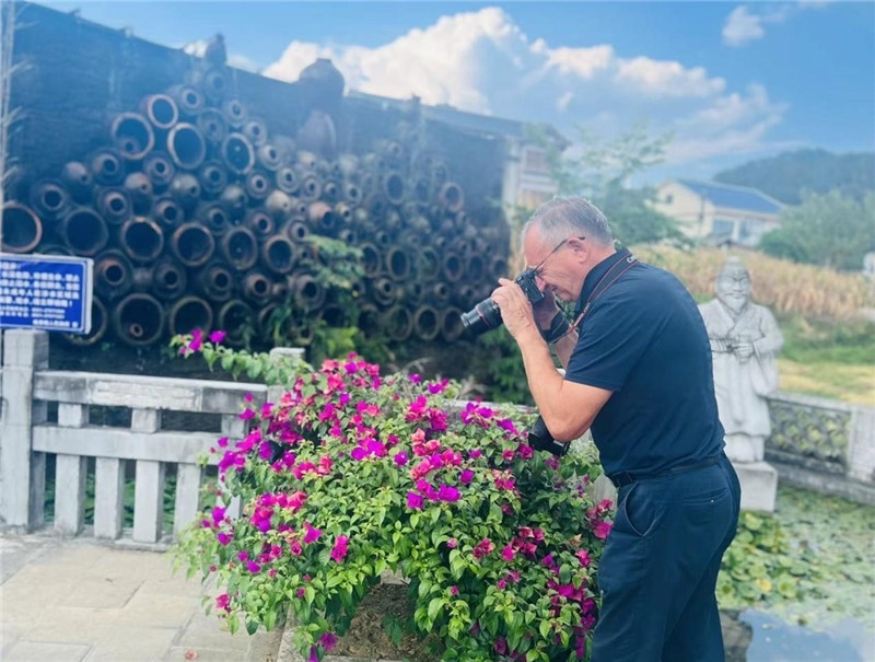 遠(yuǎn)處黔北民居錯(cuò)落有致，近處一只黑色的蝴蝶穿梭于粉紫色三角梅花叢間隙，與俄羅斯“大歐亞”總編輯弗拉基米爾·別列日內(nèi)赫的鏡頭玩起了捉迷藏，“你追我逃，不亦樂(lè)乎”。（張亞欣攝）