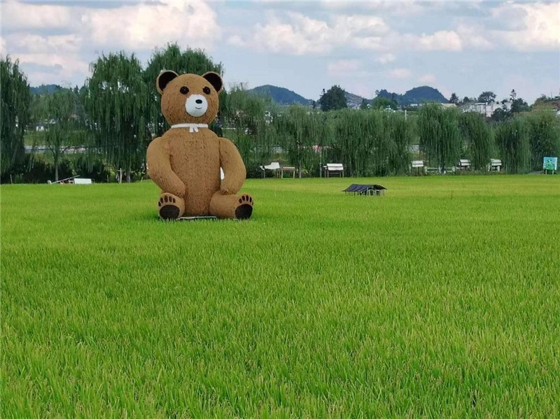 稻穗搖曳，垂柳依依，山嵐多姿，好一幅歲月靜好山鄉(xiāng)恬靜圖。這憨厚俏皮的熊玩偶造型，像是亂入其中，形成現(xiàn)代與傳統(tǒng)、好動(dòng)與寧?kù)o的反差感，讓人過(guò)目不忘，也讓人莞爾一笑。（哈薩克斯坦鳳凰24新聞社總編輯兼首席執(zhí)行官克馬爾·馬山羅攝）