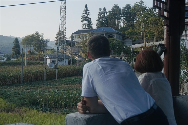 望得見(jiàn)山，看得見(jiàn)水，記得住鄉(xiāng)愁。每個(gè)人心中都有一個(gè)屬于自己的“花茂村”，在這方心田，走遍千山萬(wàn)水，鄉(xiāng)音未改鬢毛衰。吉爾吉斯斯坦《比什凱克晚報(bào)》第一副總編輯妮娜·尼奇博洛娃與《中國(guó)與俄羅斯》雜志社社長(zhǎng)奧列格·別列日內(nèi)赫攝在花茂村民居屋檐下并肩佇立，眺望山水，尋覓鄉(xiāng)愁。（李光裕攝）