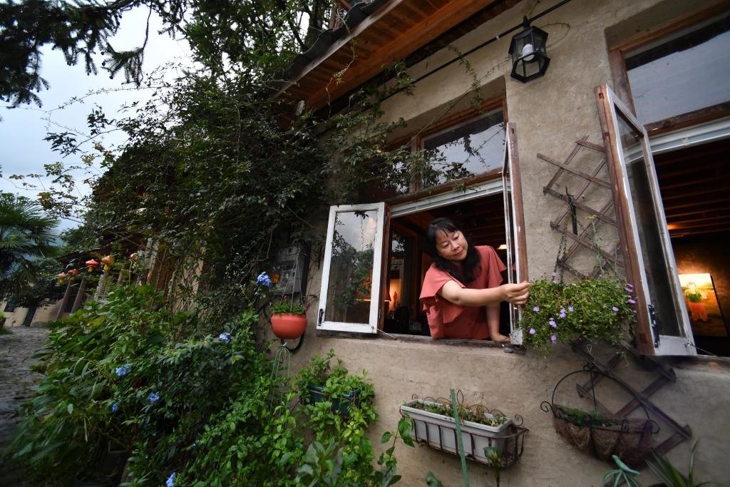 8月29日，在福建省屏南縣熙嶺鄉(xiāng)，龍?zhí)洞濉靶麓迕瘛泵泛暝诖蚶碜约航?jīng)營(yíng)的民宿外墻裝飾花盆。新華社記者姜克紅 攝