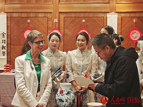 現(xiàn)場的非遺傳承人為英國觀眾展示畫技。人民網(wǎng)記者 邢雪攝