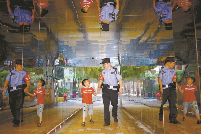 ?7月16日，重慶市公安局江北區(qū)分局一名民警在巡邏途中遇到一個(gè)獨(dú)自玩耍的小男孩，民警將其送回家。王洪平攝