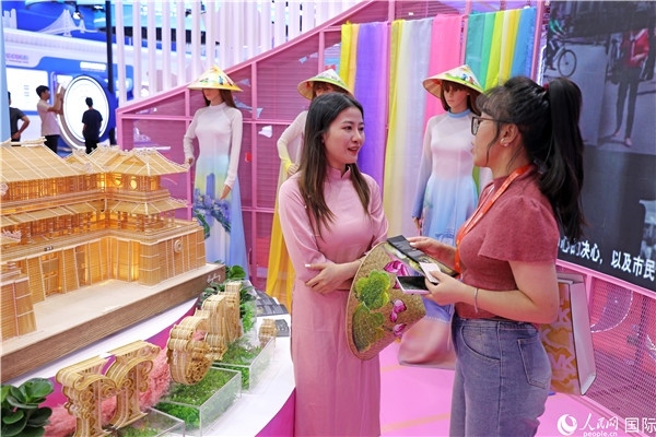 參觀者在東博會(huì)越南展區(qū)同工作人員咨詢交談。人民網(wǎng)記者 趙益普攝