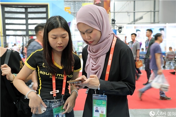 東博會(huì)現(xiàn)場(chǎng)，馬來西亞展商在同中方工作人員交談。人民網(wǎng)記者 趙益普攝