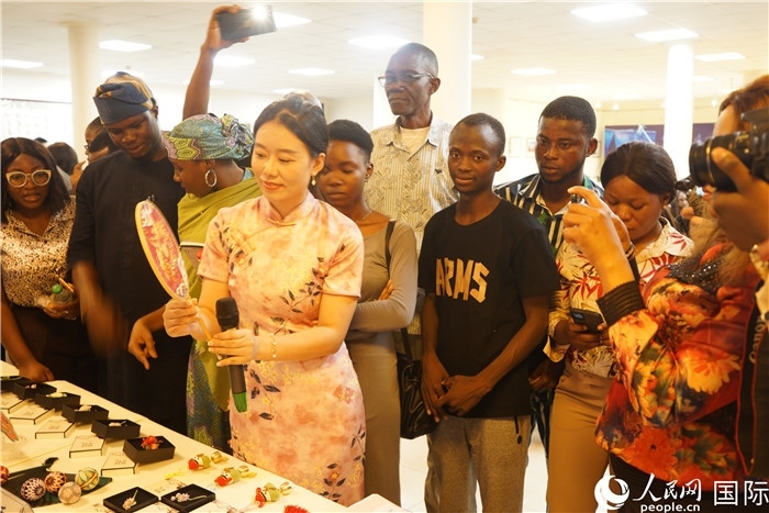 向尼日利亞觀眾介紹中國(guó)刺繡。人民網(wǎng)記者 姜宣攝