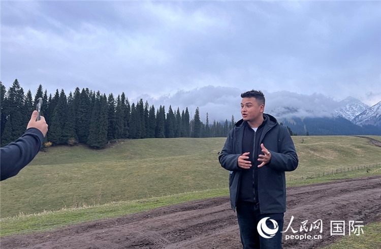 在庫爾德寧，吾買爾江被雪山美景震撼，即興錄制了短視頻作品。人民網(wǎng)記者曾書柔攝