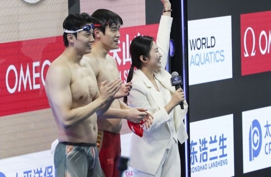  10月18日，汪順（左）和潘展樂在男子100米混合泳決賽后。新華社記者 方喆 攝