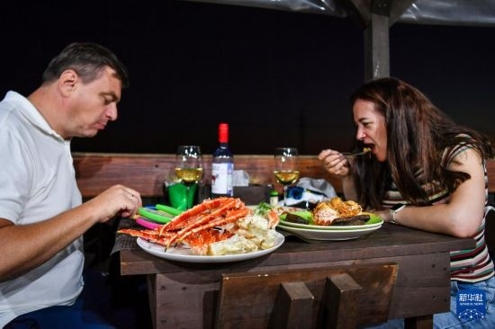 9月2日，食客們在俄羅斯符拉迪沃斯托克的一家餐館品嘗帝王蟹。新華社記者 曹陽 攝