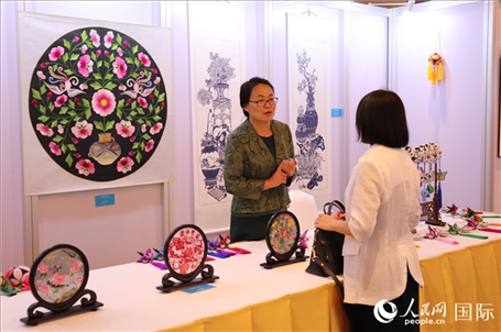 青海非遺文化傳承人向嘉賓介紹展品。人民網(wǎng)實(shí)習(xí)生姚欣可攝