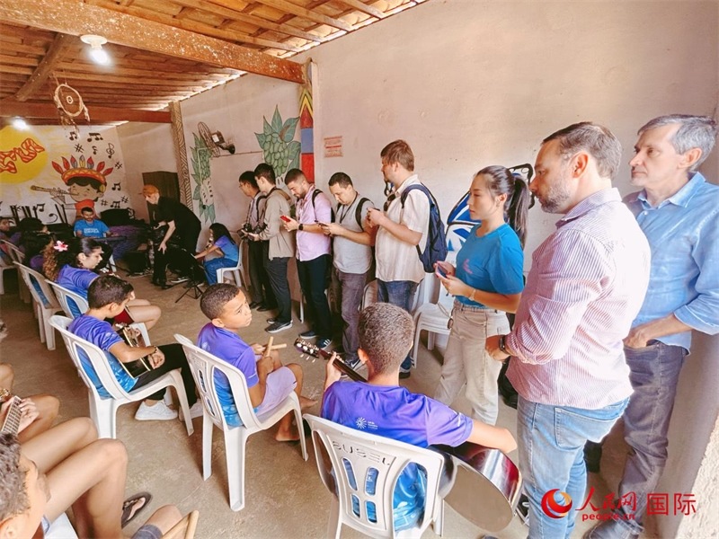  受益于中國企業(yè)的“青少年成長”項目，700多名當(dāng)?shù)厍嗌倌甑囊魳泛妥闱驂粝氩迳狭顺岚?。圖為聯(lián)合采訪團正在采訪參加音樂培訓(xùn)的孩子們。 人民網(wǎng)記者 陳一鳴攝