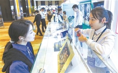 在北京麗澤商務(wù)區(qū)，工作人員（右一）介紹數(shù)字人民幣SIM卡硬錢(qián)包。新京報(bào)記者 陶冉攝