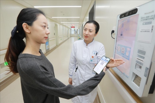 醫(yī)護(hù)人員引導(dǎo)患者在自助機(jī)前辦理自助入院手續(xù)。圖片來(lái)源：山東第一醫(yī)科大學(xué)第二附屬醫(yī)院