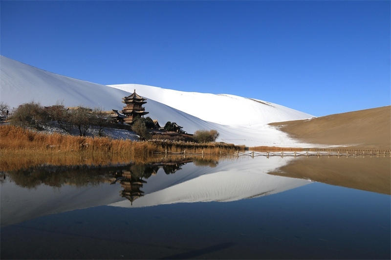 鳴沙山月牙泉景區(qū)雪景。敦煌市委宣傳部供圖，張曉亮攝
