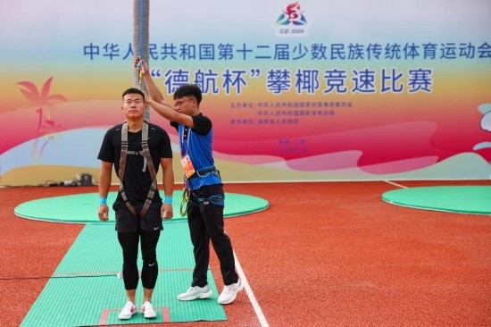 11月23日，工作人員為上海隊(duì)選手付樂樂（左）系安全繩。新華社記者 楊植森 攝