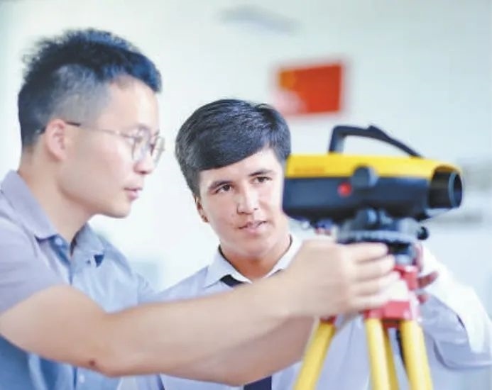 在塔吉克斯坦首都杜尚別的魯班工坊，來自天津城市建設(shè)管理職業(yè)技術(shù)學(xué)院的老師（左）為當(dāng)?shù)貙W(xué)生提供指導(dǎo)。新華社記者 鄭開君 攝