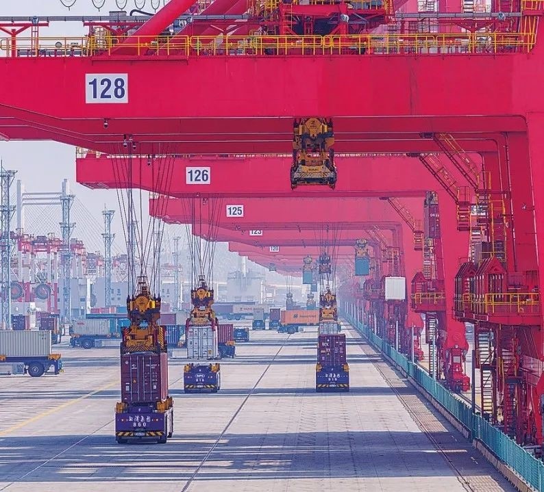 共建“一帶一路”國家在工作制度對接、技術(shù)標(biāo)準(zhǔn)協(xié)調(diào)、檢驗(yàn)結(jié)果互認(rèn)等方面強(qiáng)化合作、統(tǒng)一標(biāo)準(zhǔn)，貿(mào)易自由化便利化水平不斷提升。上海洋山港海關(guān)對接共建國家進(jìn)出口貨物相關(guān)標(biāo)準(zhǔn)，推動(dòng)通關(guān)一體化方式申報(bào)，提升通關(guān)效率。圖為無人駕駛的全自動(dòng)導(dǎo)引車在洋山港穿梭往來，搬運(yùn)集裝箱。王初 攝