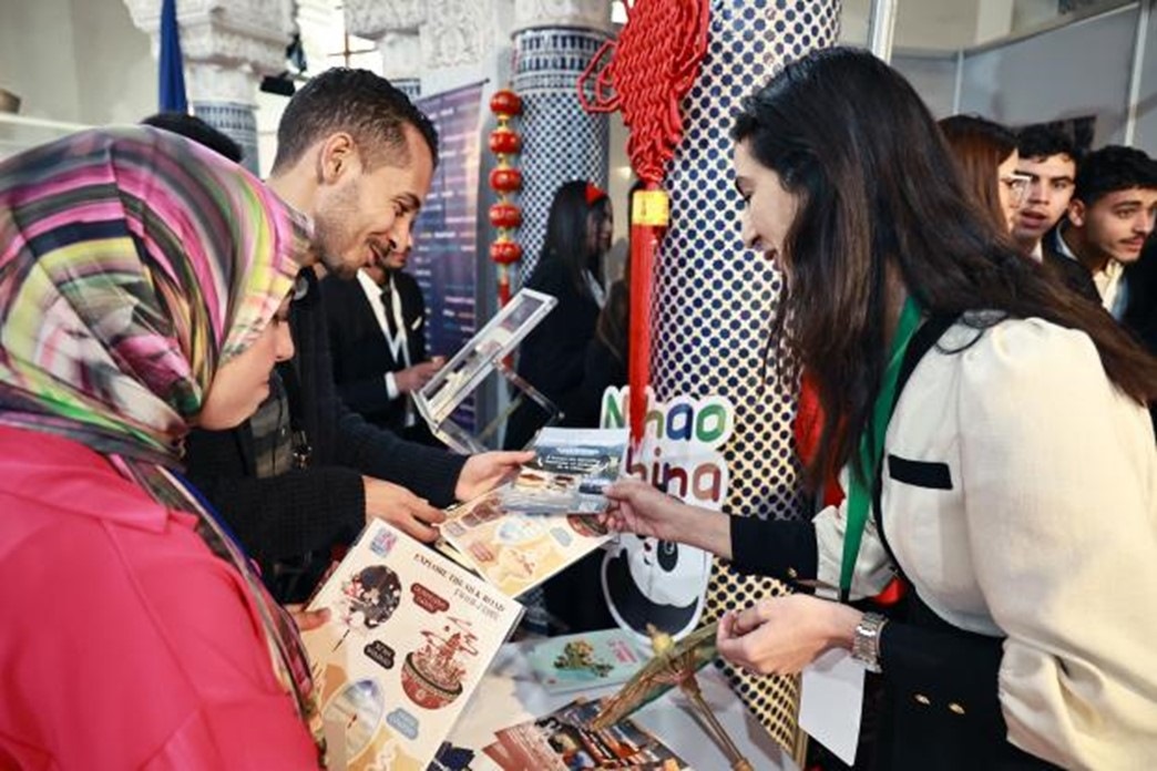 摩洛哥觀眾在中國展臺前觀看宣傳資料。拉巴特中國文化中心供圖