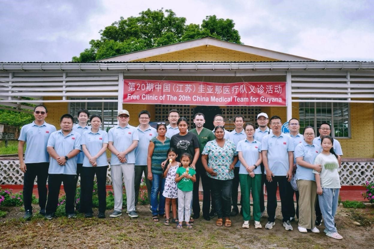 第20期中國(guó)（江蘇）援圭亞那醫(yī)療隊(duì)在圭偏遠(yuǎn)的林登高速社區(qū)開展義診后，與部分當(dāng)?shù)鼐用窈嫌啊?中國(guó)援圭醫(yī)療隊(duì)供圖