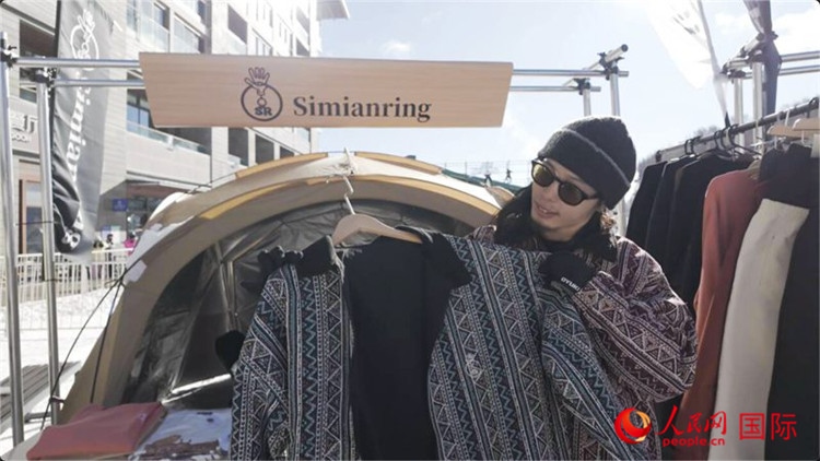 藤田周正在展示自己設(shè)計的滑雪服。人民網(wǎng)記者 袁蒙攝