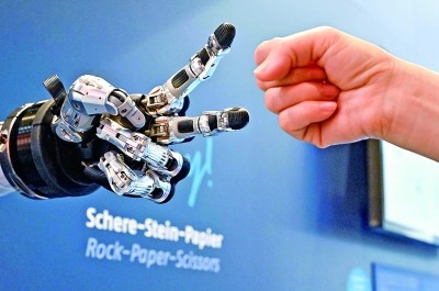 在德國(guó)漢諾威工博會(huì)上，參觀者與一款智能機(jī)器人進(jìn)行“石頭剪子布”游戲。新華社發(fā)