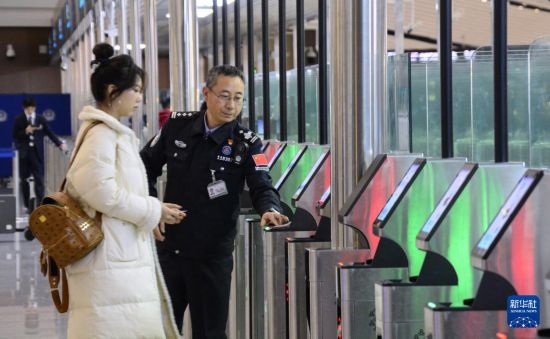 1月2日，大興機場邊檢站警察指導旅客使用自助出境設備。新華社記者 李欣 攝
