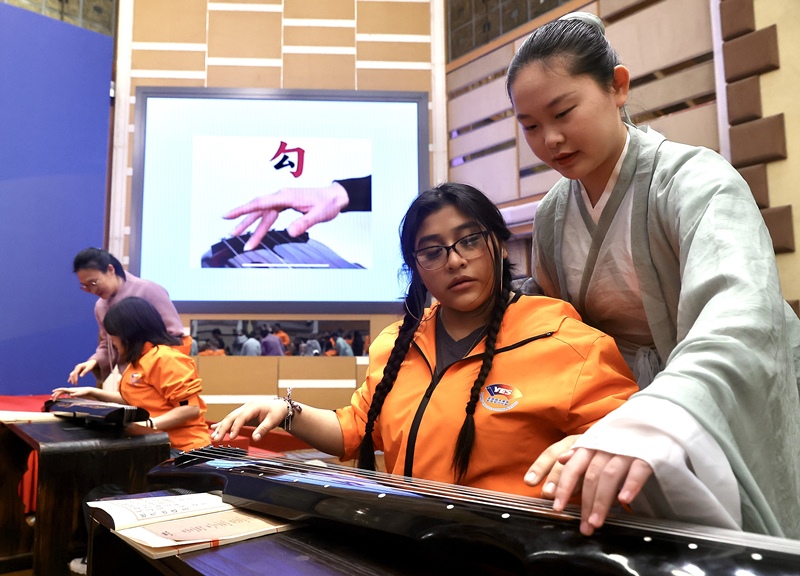 2024年3月20日，美國(guó)華盛頓州中學(xué)生代表團(tuán)北京大學(xué)交流活動(dòng)在北京大學(xué)英杰交流中心舉行。圖為來自華盛頓州的中學(xué)生體驗(yàn)古琴。