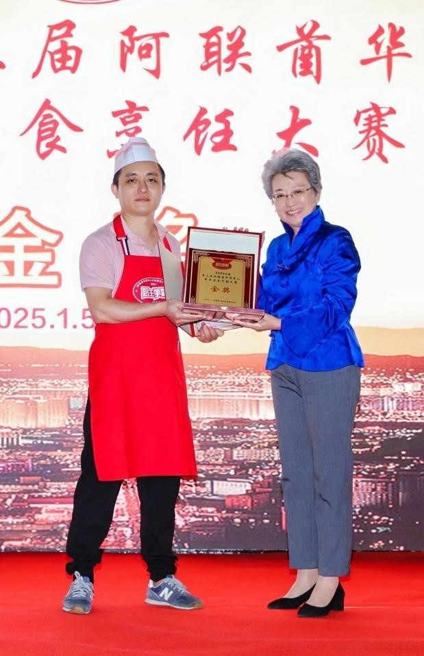 中國駐迪拜總領(lǐng)事歐渤芊（右）為金獎獲得者頒獎。主辦方供圖