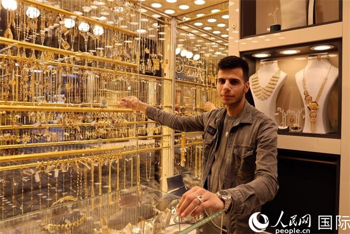 一名銷(xiāo)售員展示黃金飾品。人民網(wǎng) 伊納斯·易卜拉欣攝