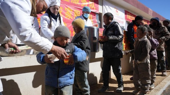 1月14日，廚師們正在給前來(lái)用餐的小朋友們打飯。新華社記者 邱星翔 攝