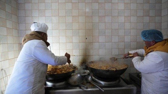 1月14日，服務(wù)隊(duì)的兩名廚師正在為村民們做午飯。新華社記者 邱星翔 攝