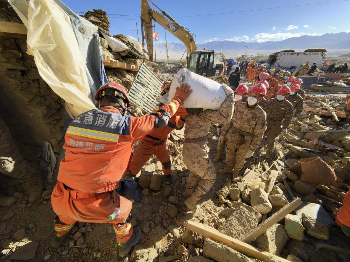 1月11日，定日縣長所鄉(xiāng)古榮村，應(yīng)急消防等救援人員排隊(duì)接力搶運(yùn)掩埋在倒塌房屋下的群眾財(cái)物。人民日?qǐng)?bào)記者楊翹楚攝
