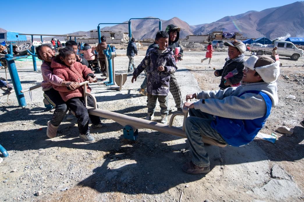 1月11日，在定日縣措果鄉(xiāng)塘仁村安置點(diǎn)，西藏星光社會(huì)工作服務(wù)中心志愿者和孩子們一起玩耍，進(jìn)行災(zāi)后心理疏導(dǎo)。人民網(wǎng)記者 翁奇羽攝