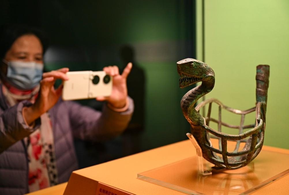 1月14日，觀眾在上海博物館蛇年迎春展拍攝展品蛇綱網(wǎng)狀銅器。新華社發(fā)（陳浩明攝）